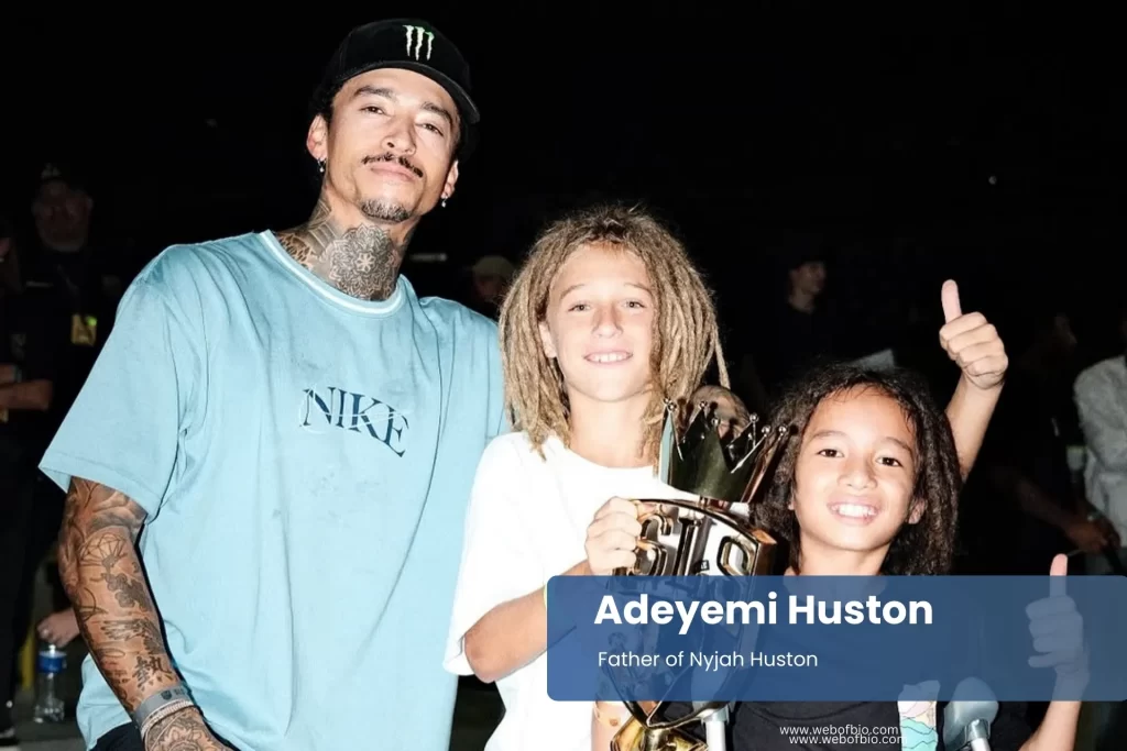 Adeyemi Huston with kids posing with a trophy.