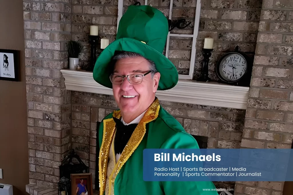 Bill Michaels in a green leprechaun costume standing in front of a fireplace.