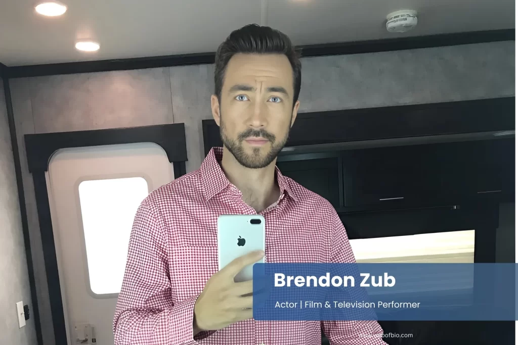 Brendon Zub in a red plaid shirt taking a selfie.