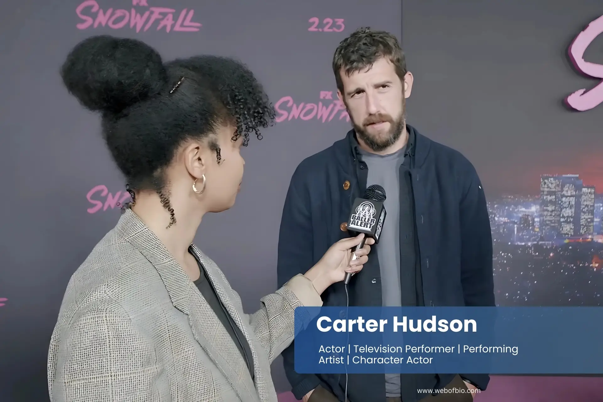 Carter Hudson talking to an interviewer on the red carpet at the snowfall premiere.