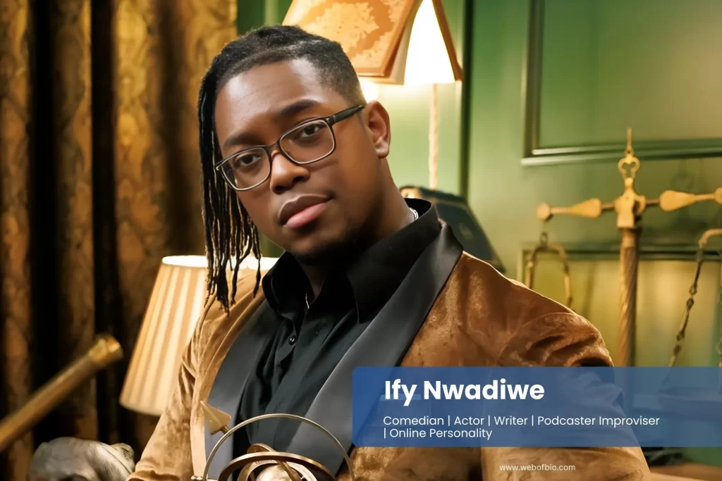 Ify Nwadiwe in a suit holding an award.