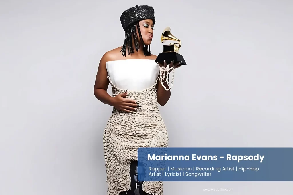 Marianna Evans is in a black and white dress holding a grammy.