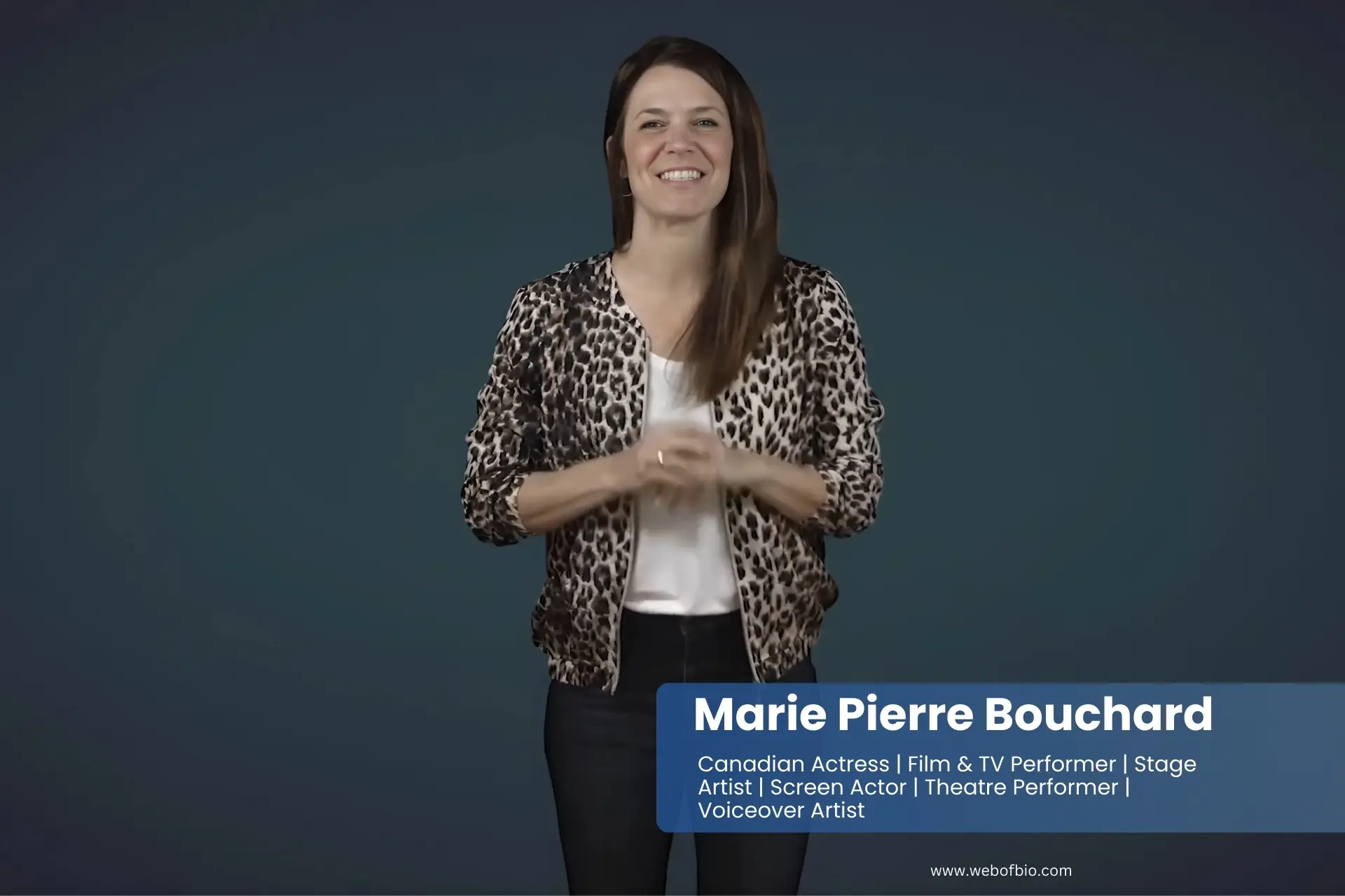 Marie Pierre Bouchard in a leopard print jacket standing in front of a blue background.