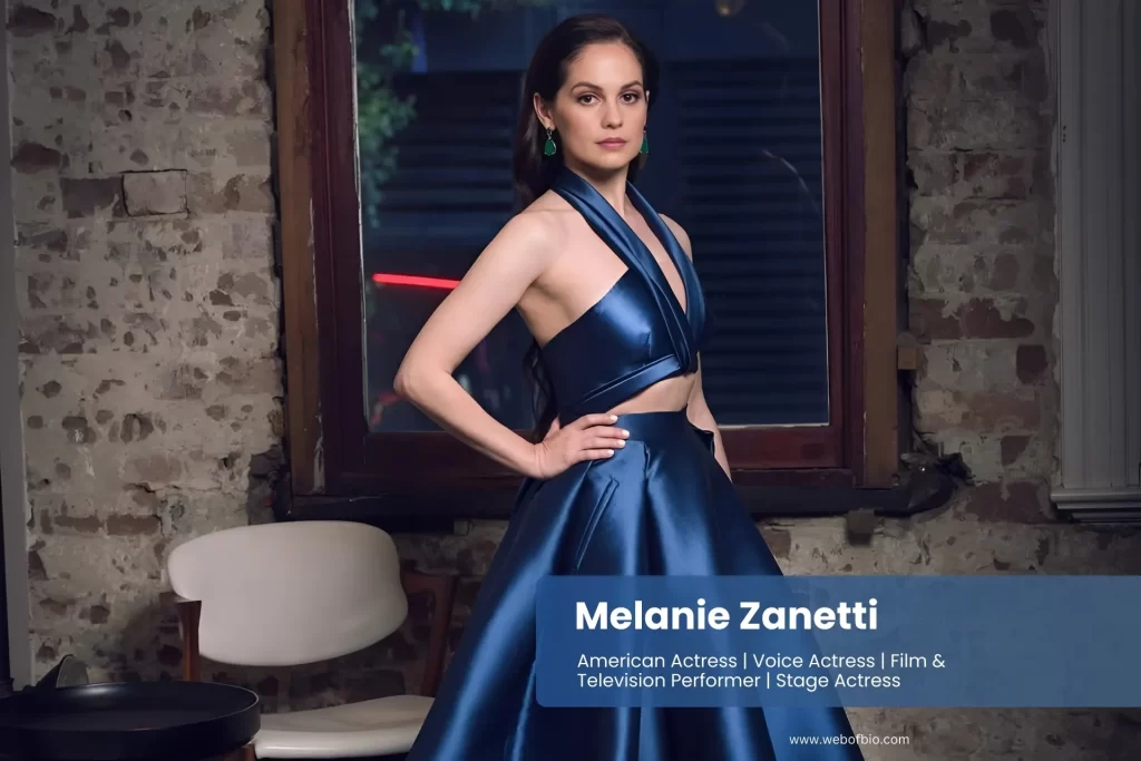 Melanie Zanetti in a blue gown posing in front of a window.