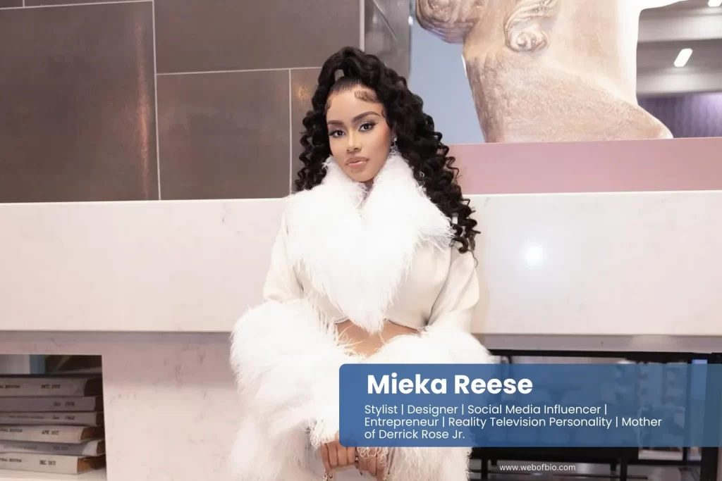 Mieka Reese in a white fur coat and thigh high boots.