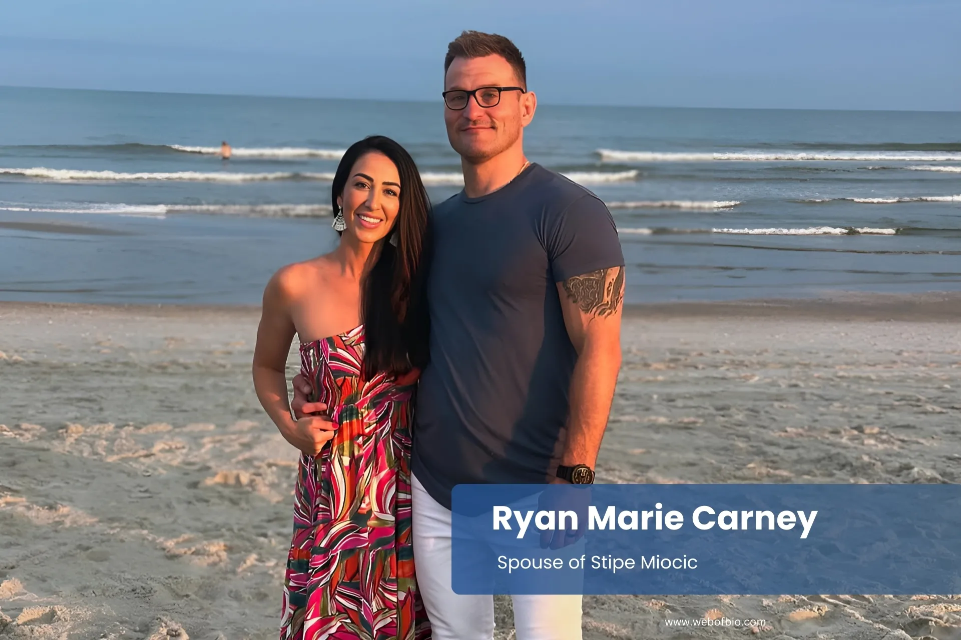 Ryan Marie Carney standing on the beach with her girlfriend in front of the ocean.
