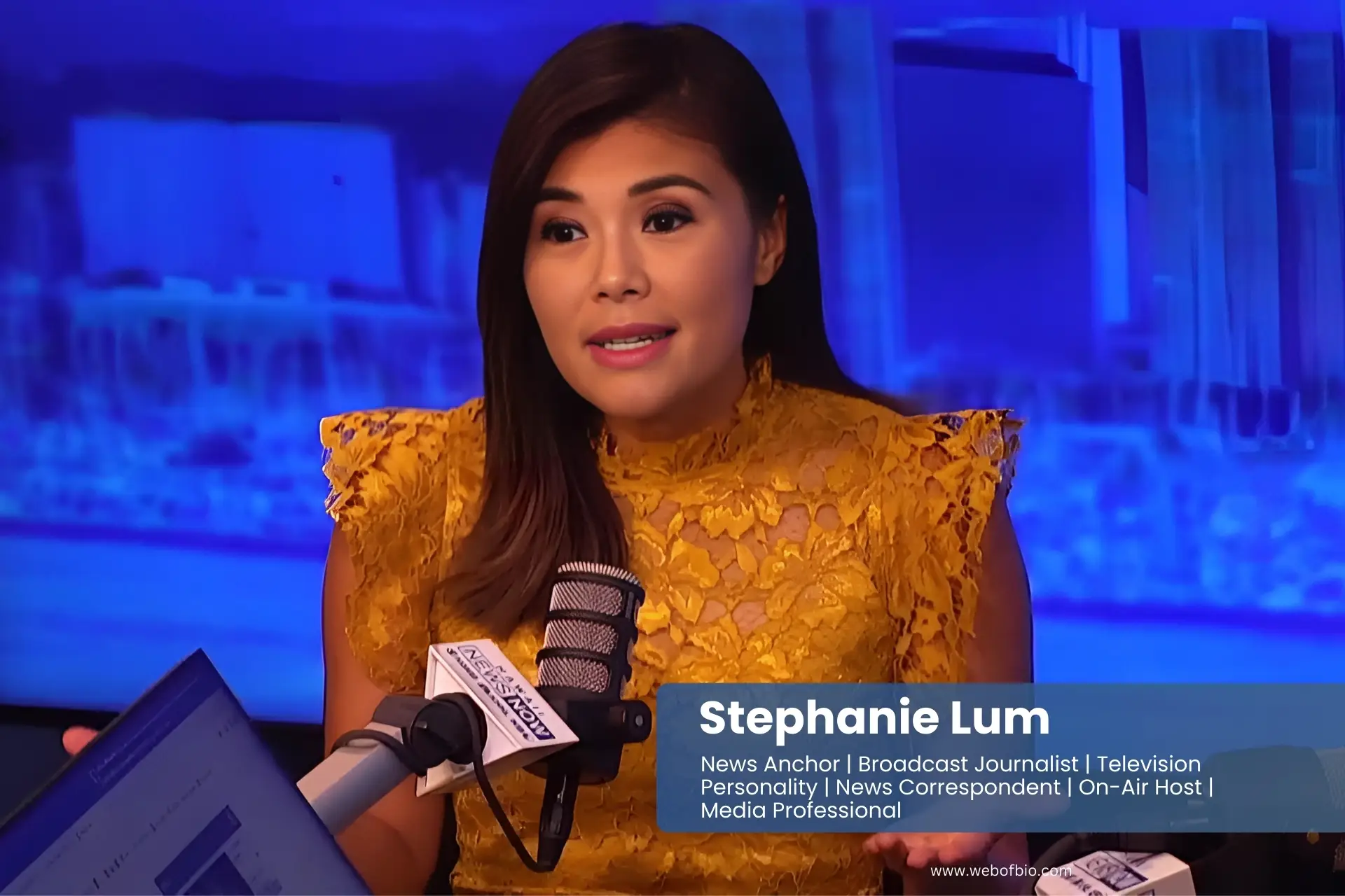 Stephanie Lum in yellow dress sits in front of a microphone, ready to speak.