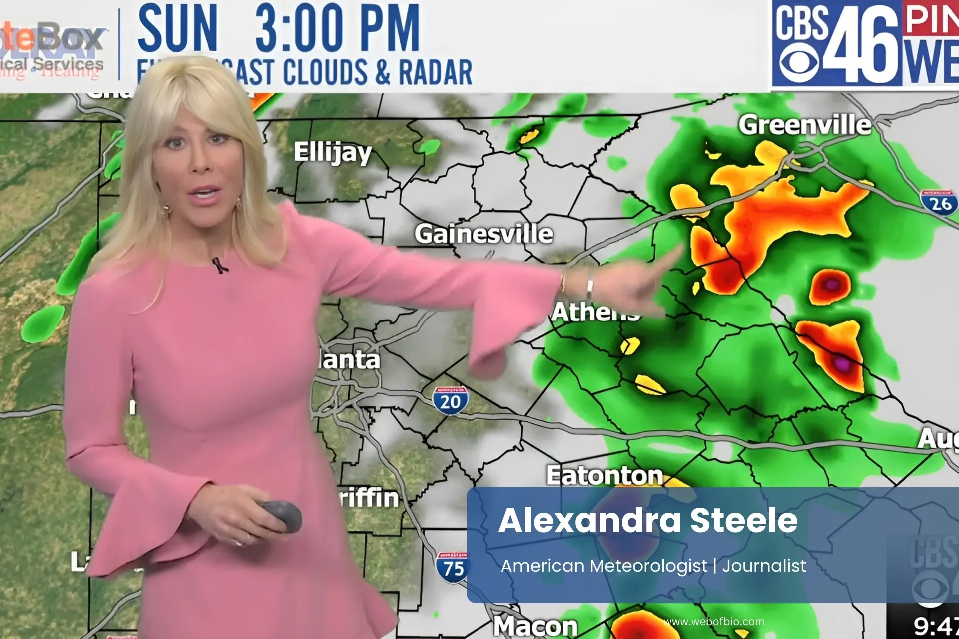 Alexandra Steele in a pink dress points at a weather map, indicating various weather patterns and forecasts.