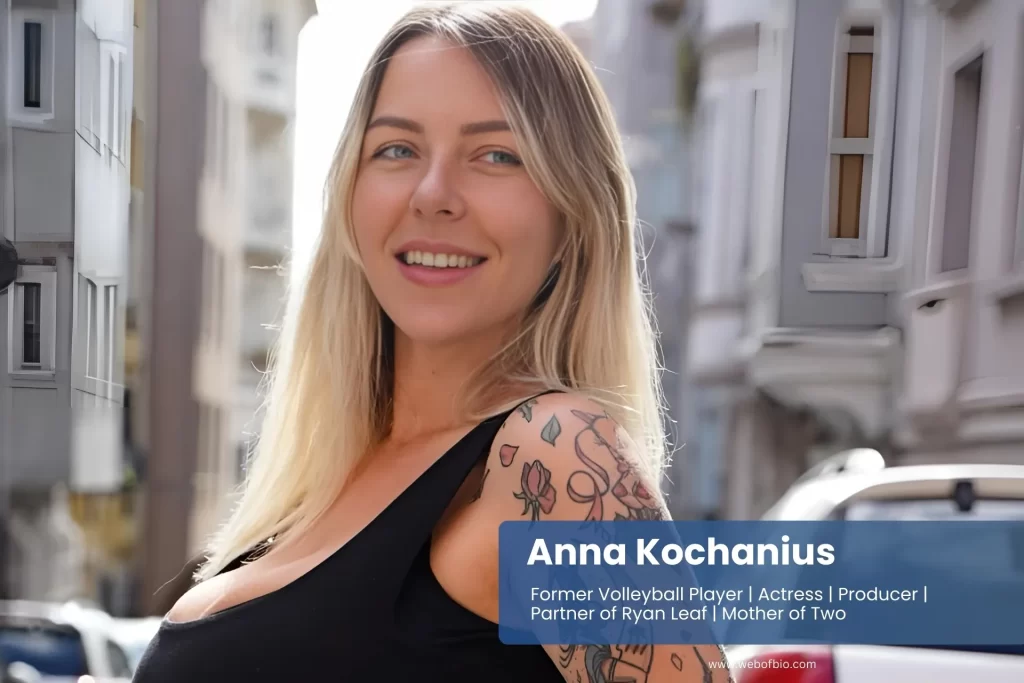 Anna Kochanius, with tattooed arms, poses confidently on a vibrant city street, showcasing her unique style and personality.