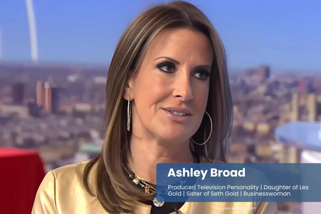 Ashley Broad smiling with crew members on television set.