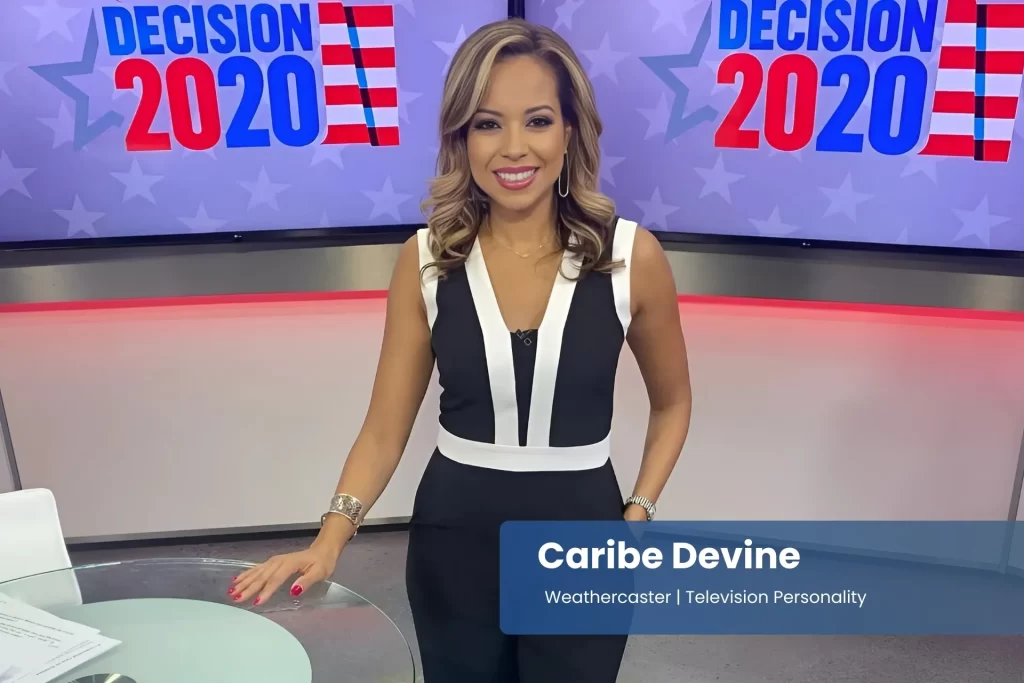 Caribe Devine in a black and white jumpsuit stands in news set.