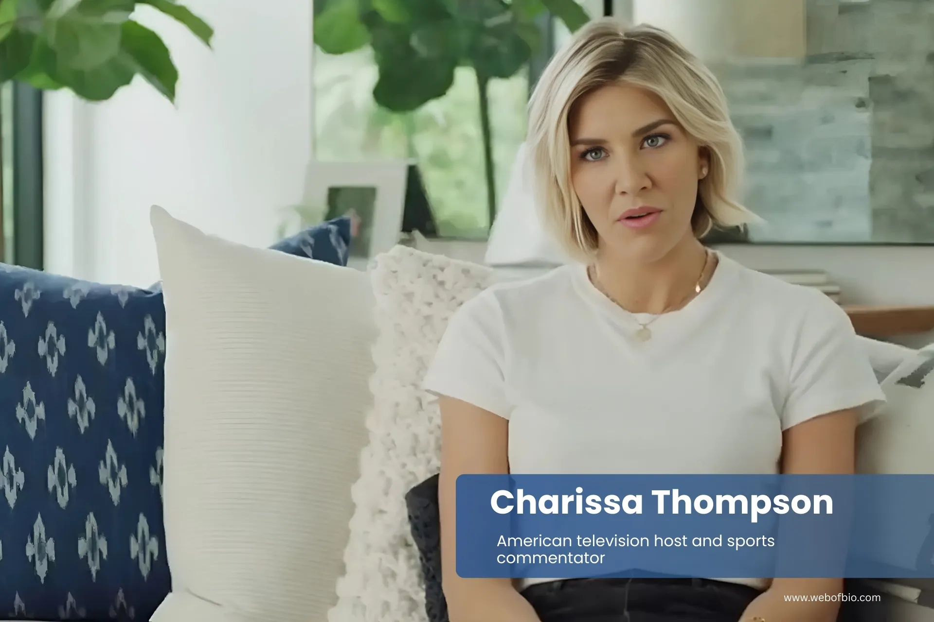 Charissa Thompson sitting on a couch wearing a white t-shirt.