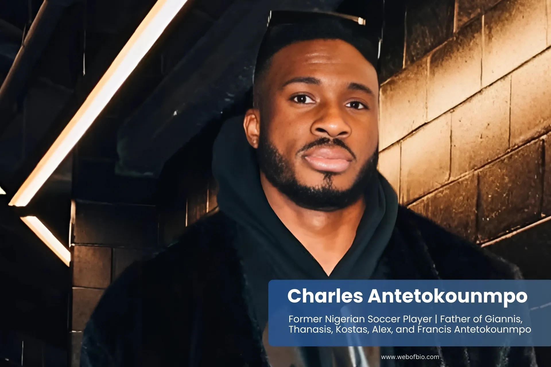Charles Antetokounmpo wearing black coat and hoodie standing confidently.