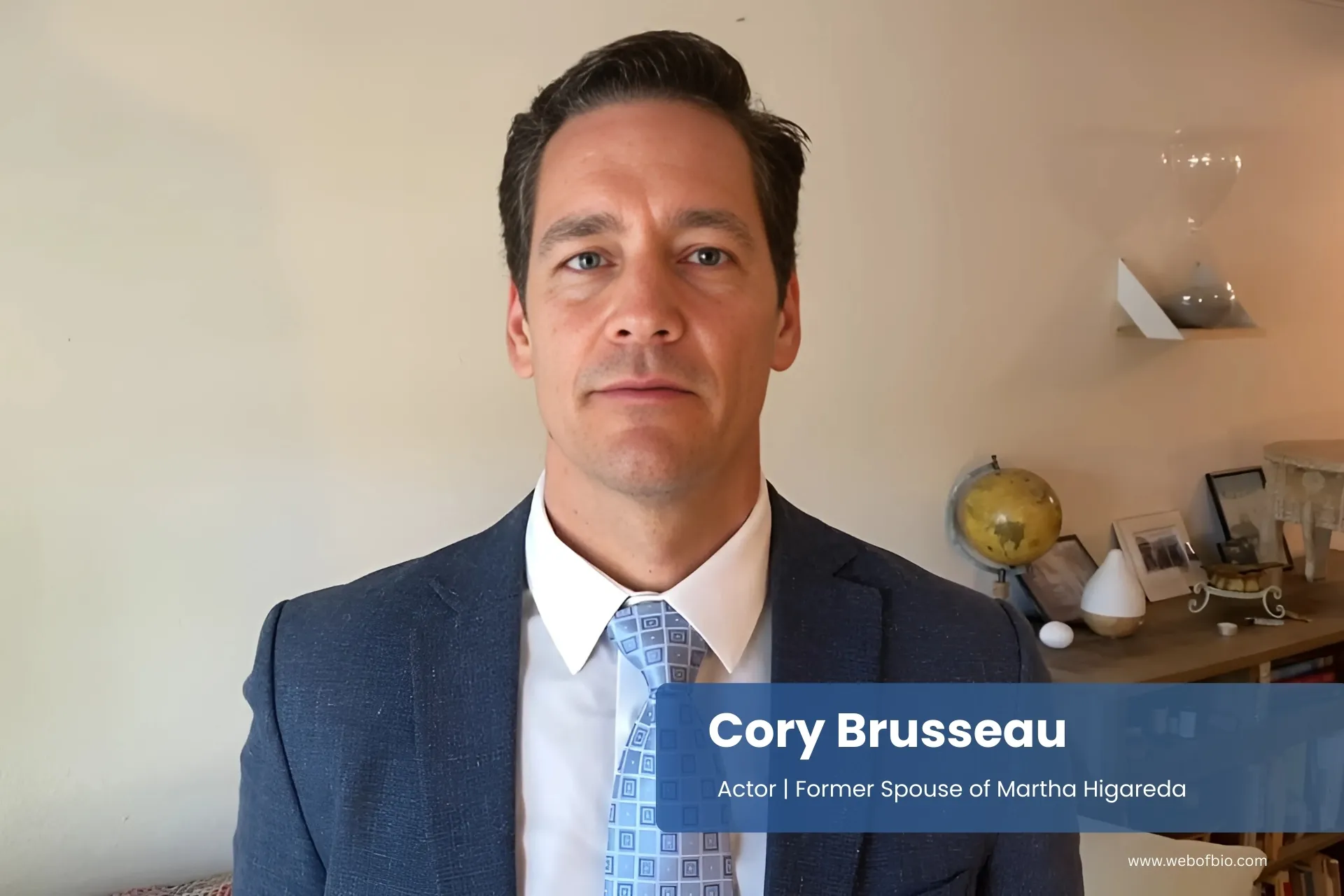 Cory Brusseau in a suit and tie standing in a living room.