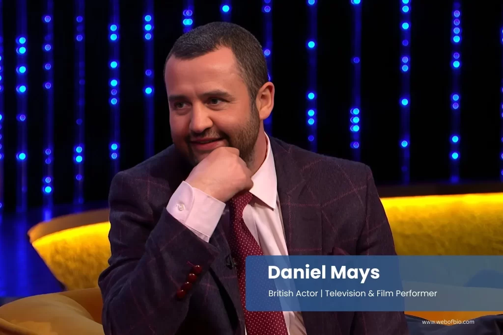 Daniel Mays in a suit and tie in interview.