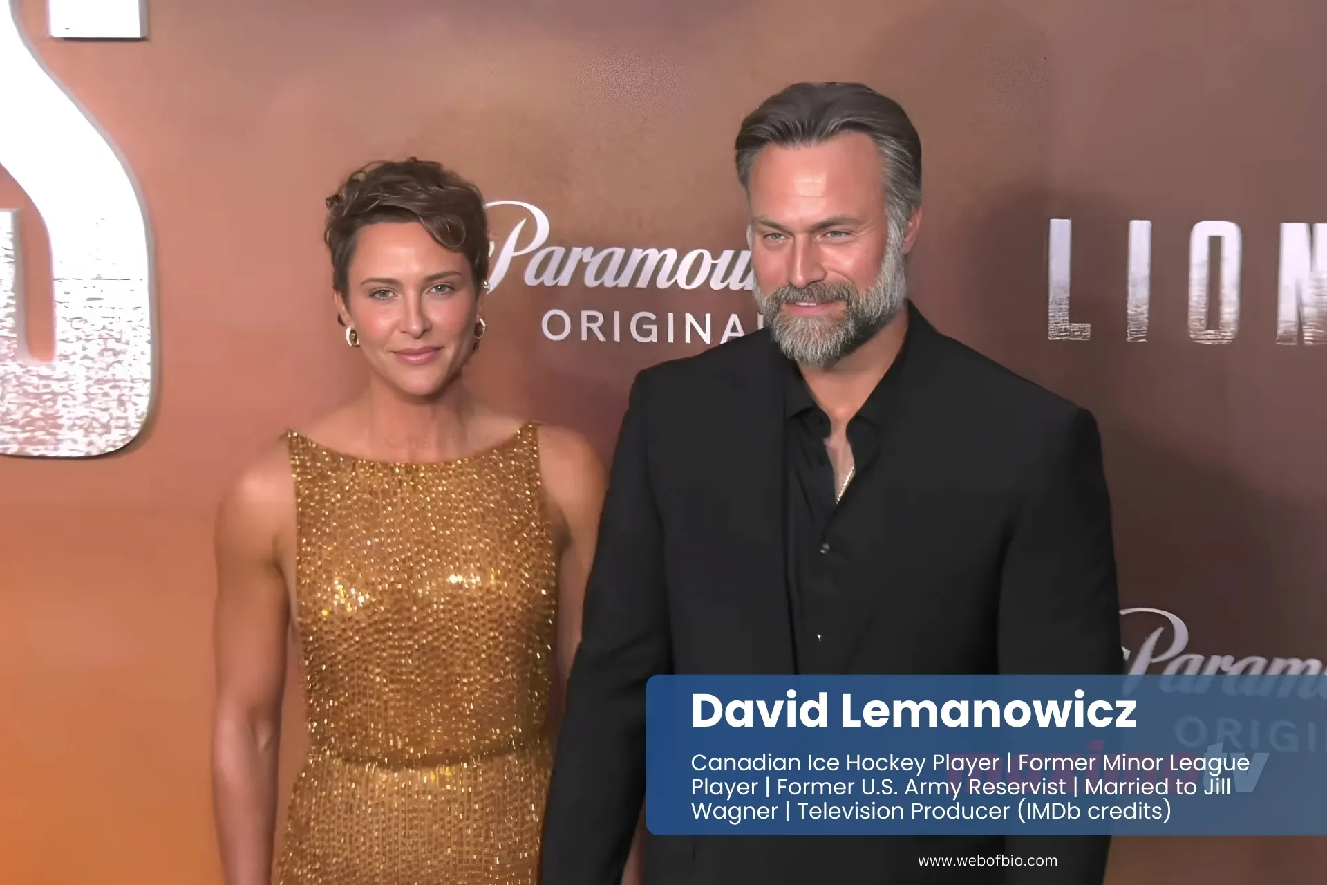 David Lemanowicz and his wife Jill Wagner pose together on a red carpet, dressed elegantly for a formal event.