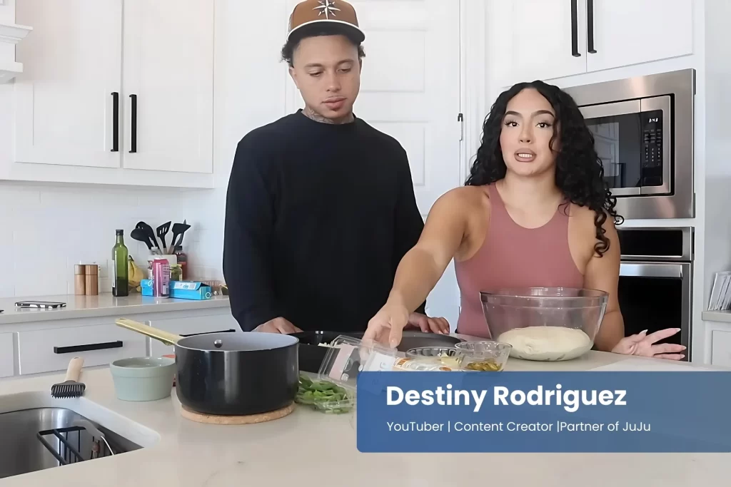 Destiny Rodriguez and JuJu are in the kitchen preparing food.