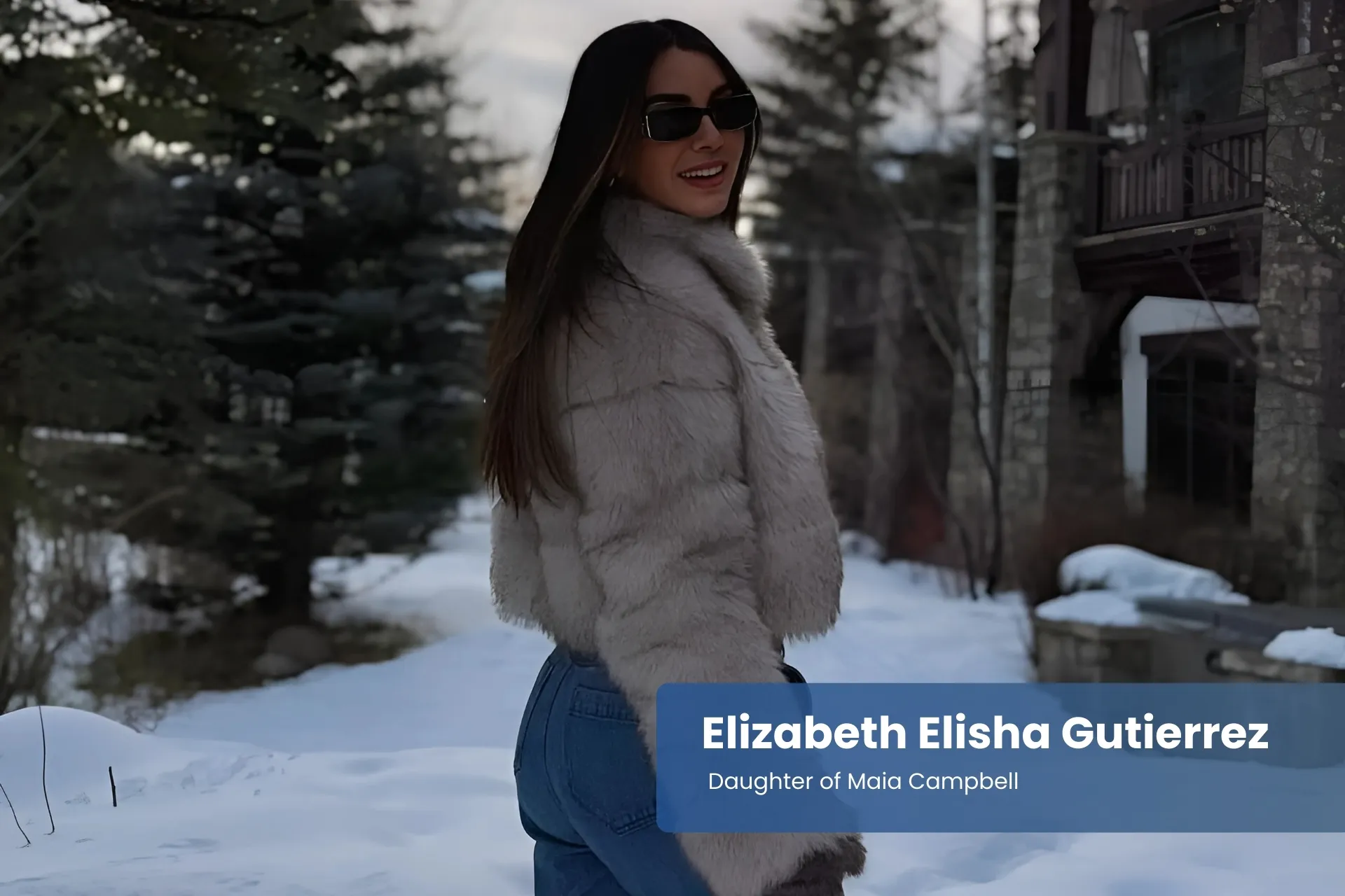 Elizabeth Elisha Gutierrez in a fur coat and jeans standing in the snow.