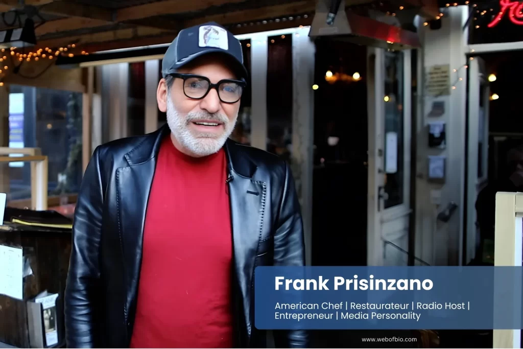 Frank Prisinzano, wearing glasses and a hat, stands outside with a neutral expression and a blurred background of trees.