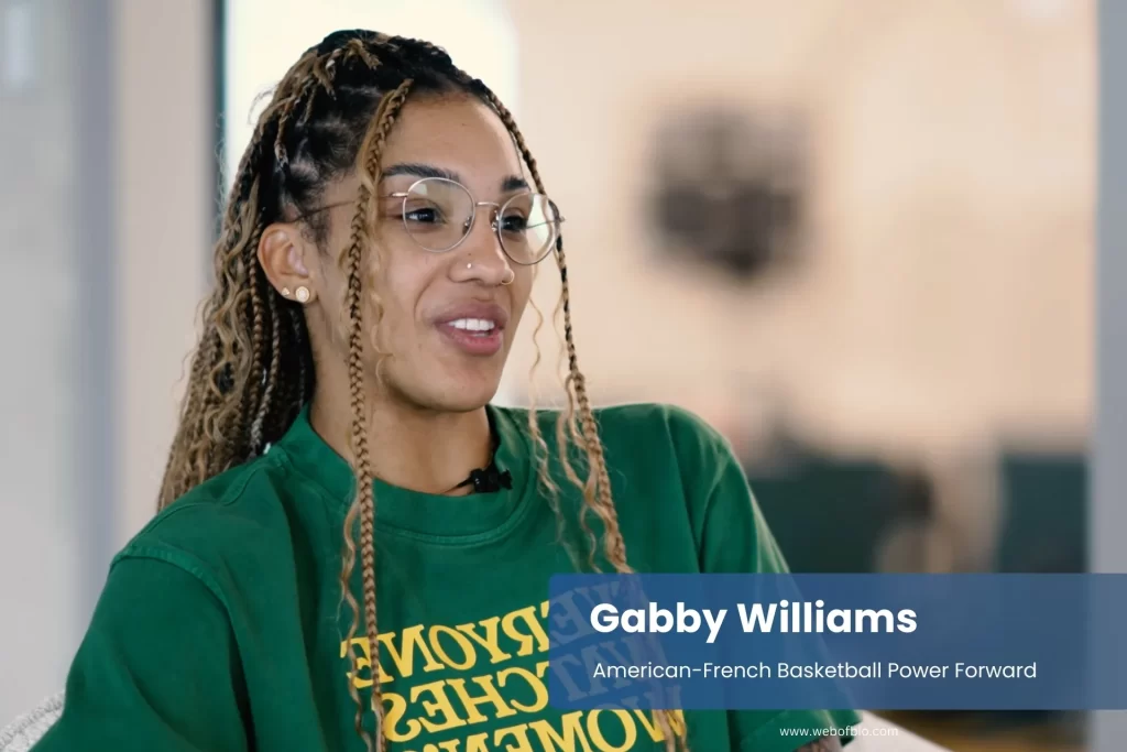 Gabby Williams in a green shirt displaying the phrase "empower women," promoting female empowerment and solidarity.