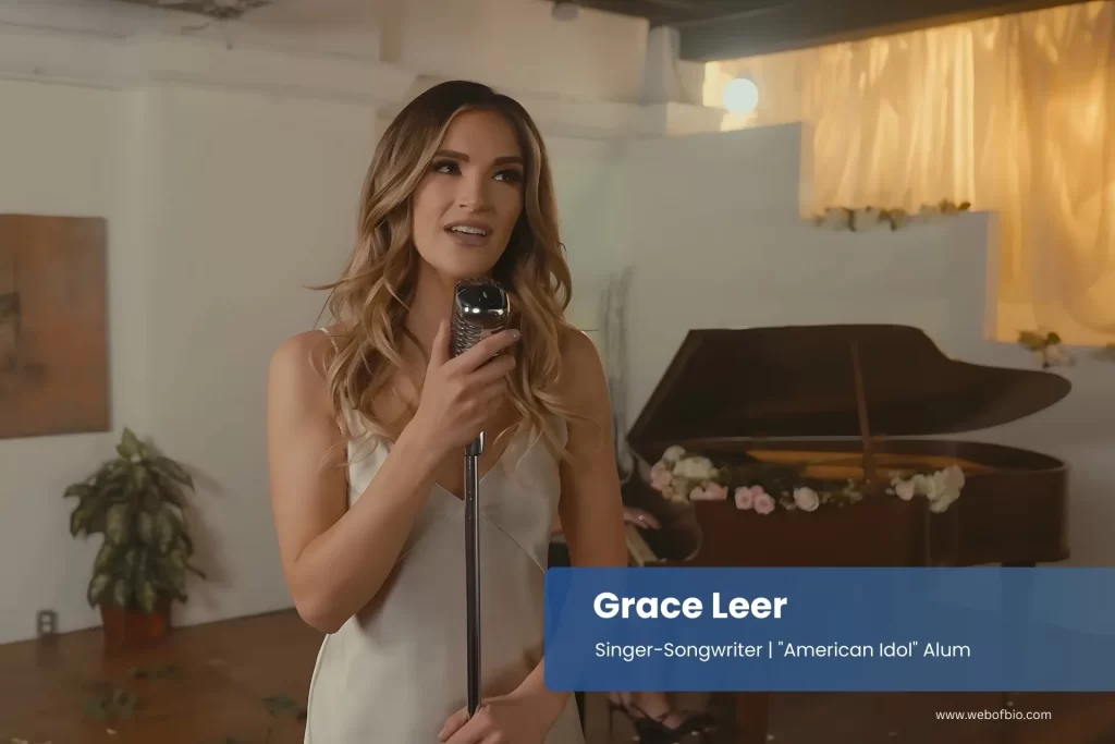 Grace Leer holding a microphone in front of a piano.