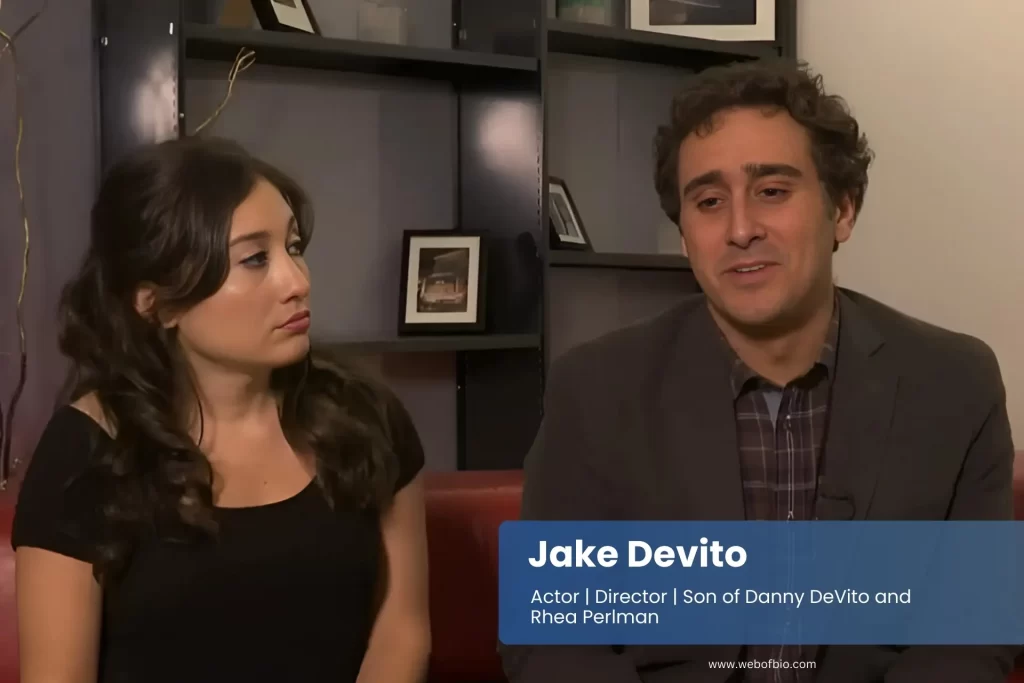 Jake Devito and his wife are sitting closely together on a couch, engaged in conversation.