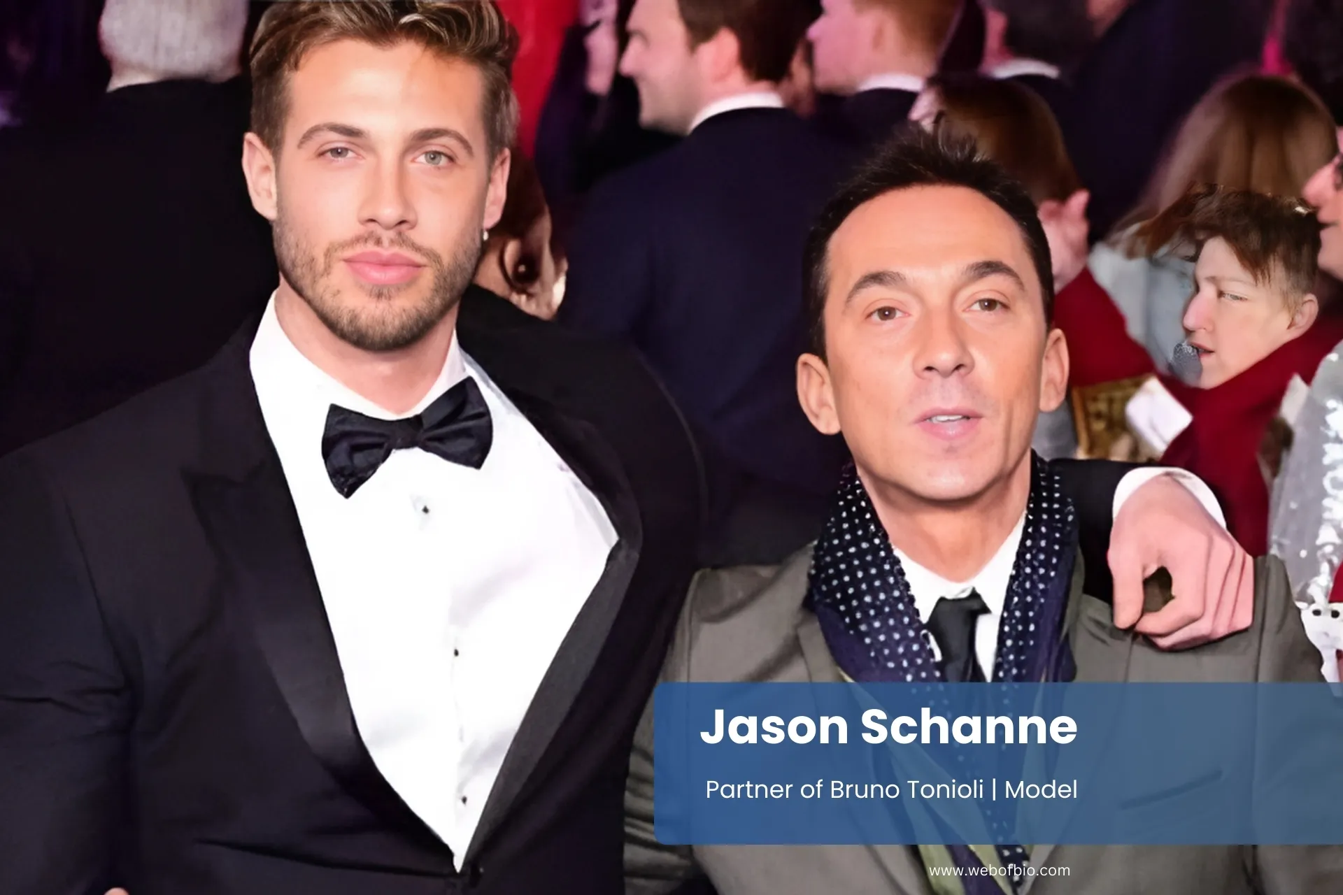 Jason Schanne and his partner Bruno Tonioli stand side by side in suits on a blue carpet, smiling at the camera.
