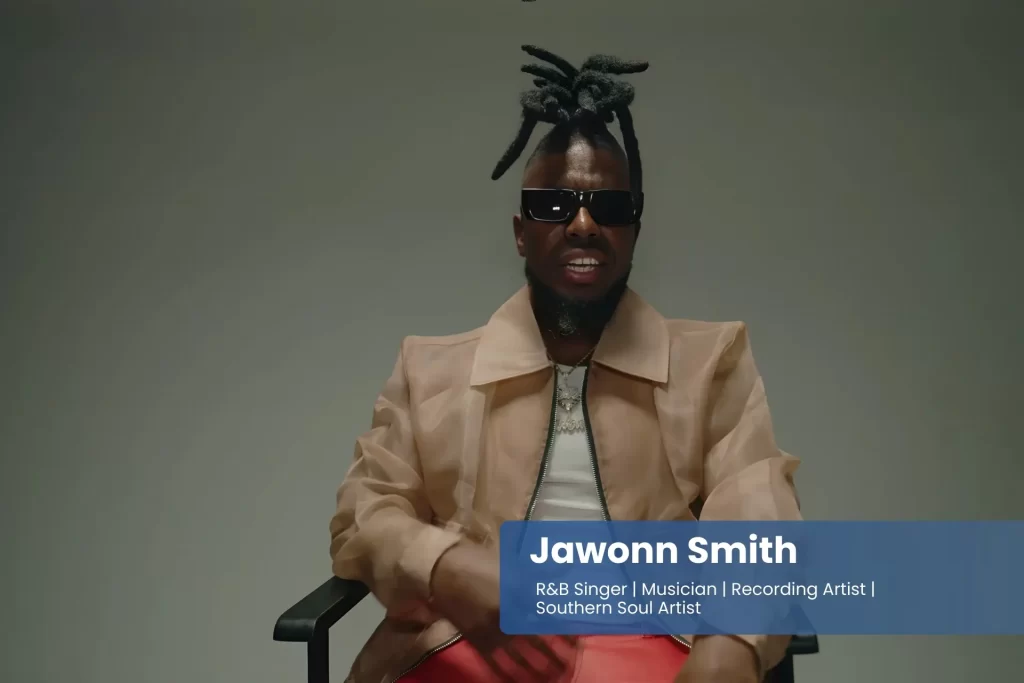 Jawonn Smith with dreadlocks sitting in a chair.