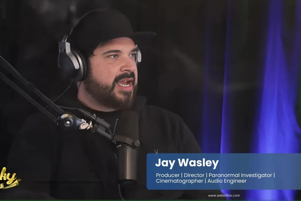Jay Wasley, with a beard and hat, broadcasts live on the radio.