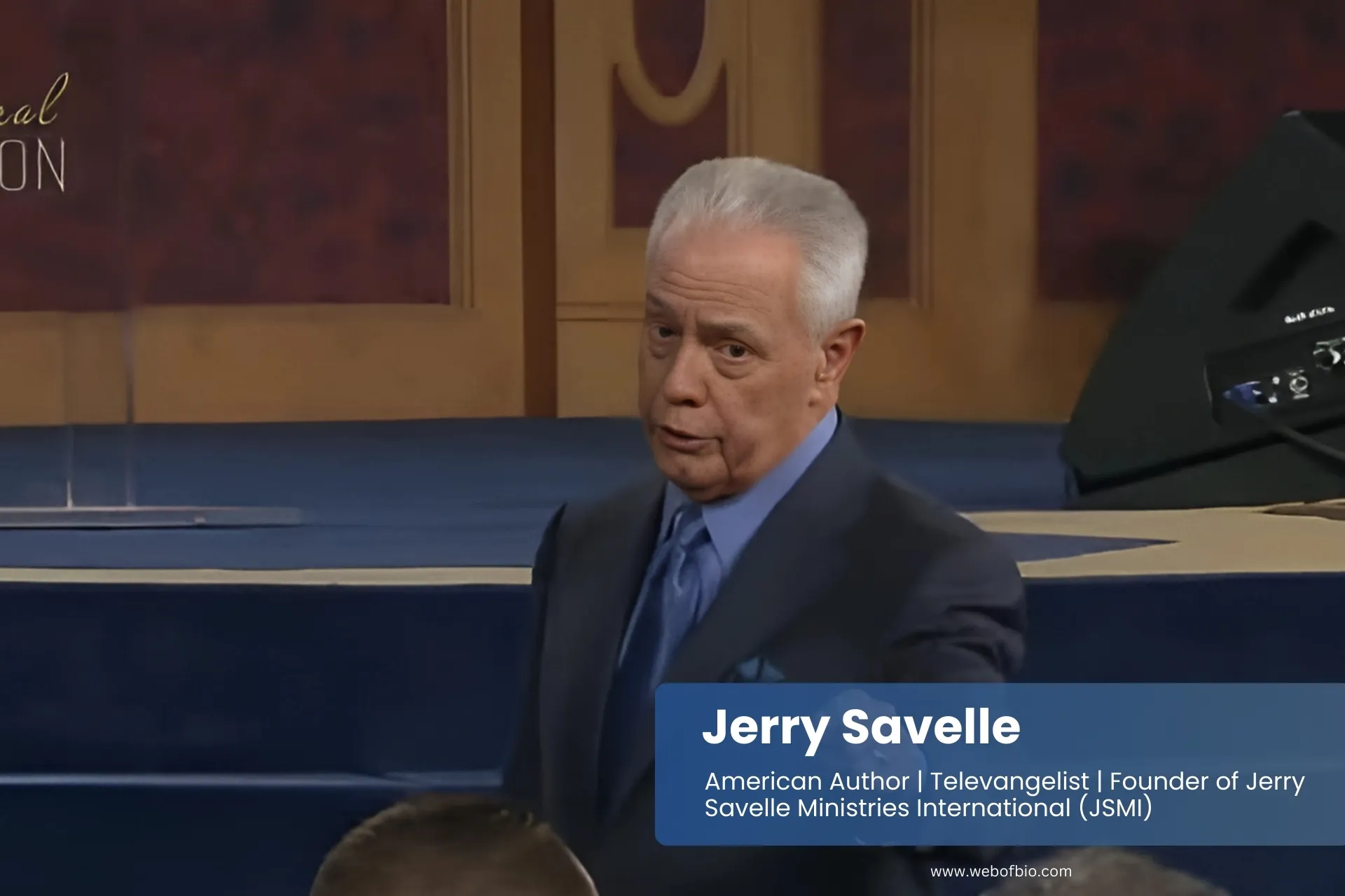 Jerry Savelle speaking in suit at conference.
