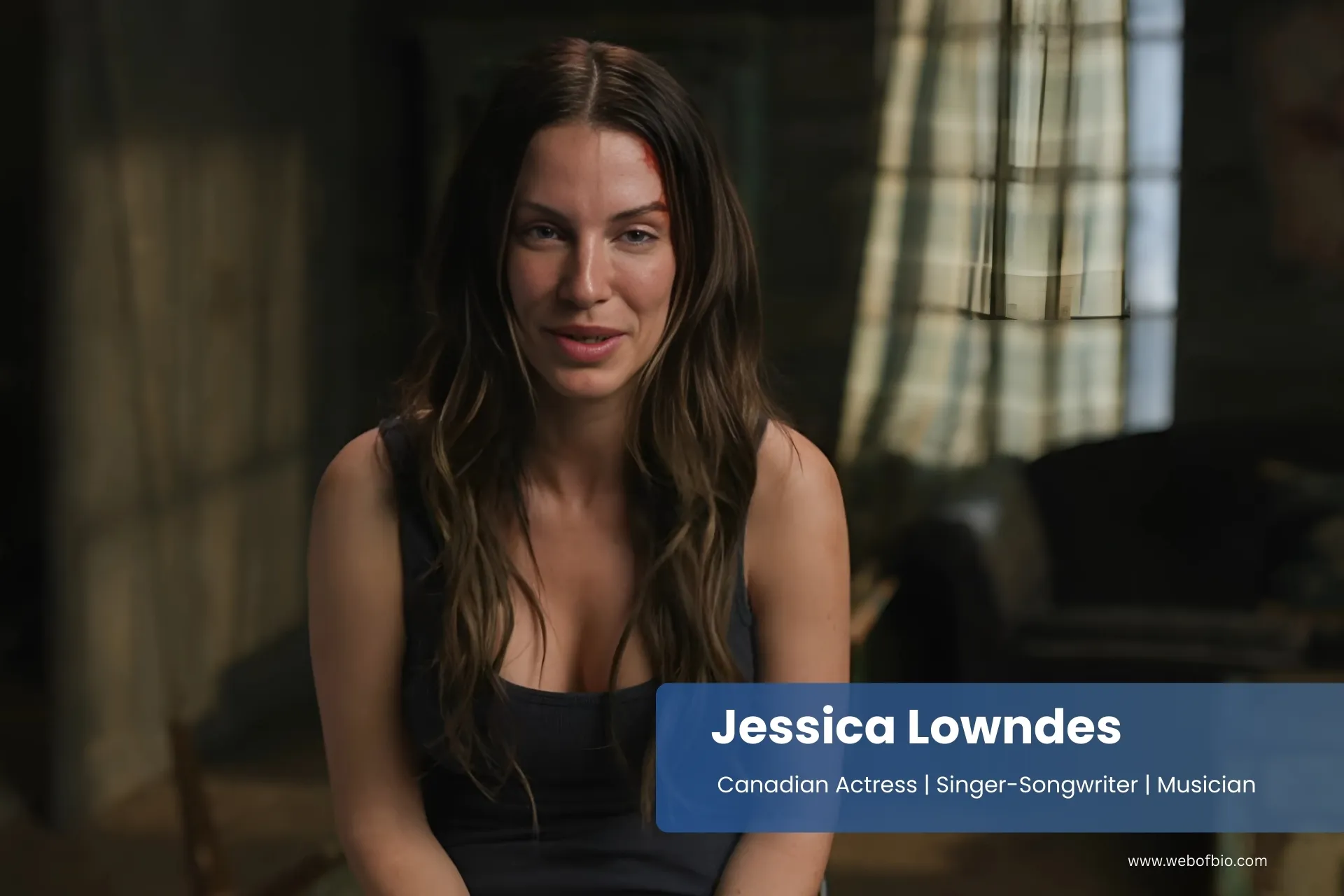 Jessica Lowndes sitting in a living room.