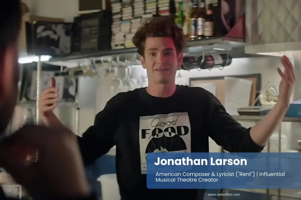 Jonathan Larson, wearing a black shirt, stands in front of a counter, looking towards the camera with a neutral expression.