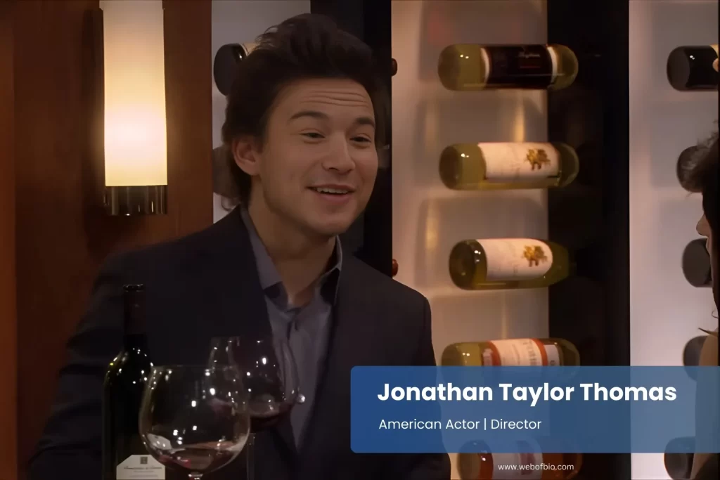 Jonathan Taylor Thomas suit smiling wine glass.