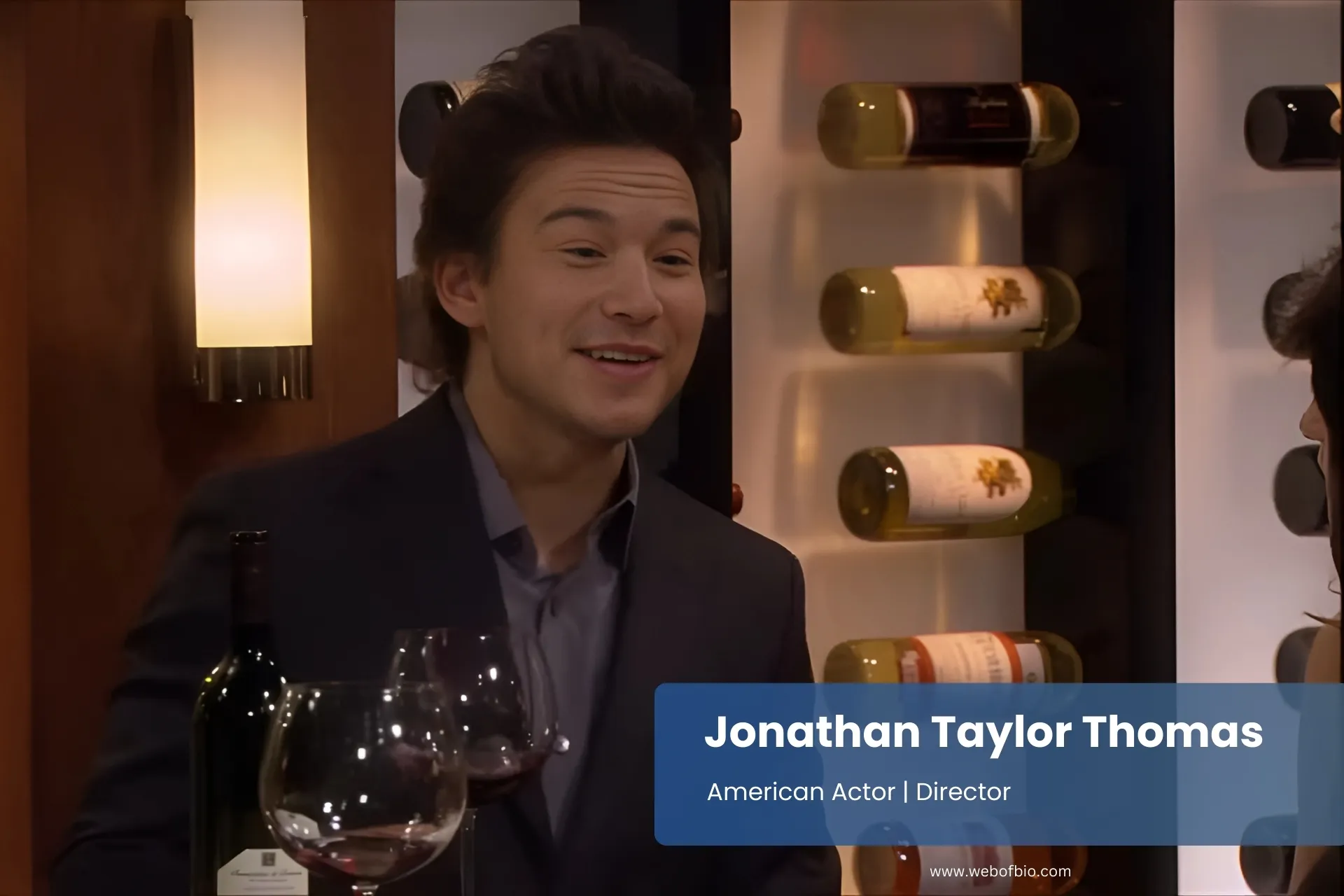 Jonathan Taylor Thomas suit smiling wine glass.
