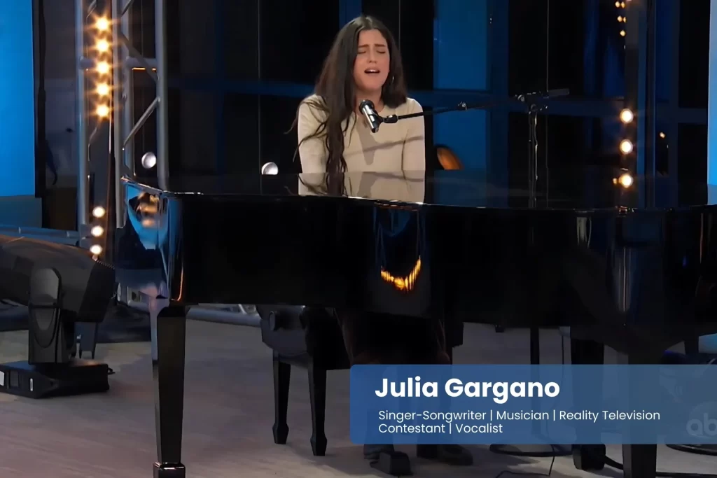 Julia Gargano is playing a piano in front of a microphone.