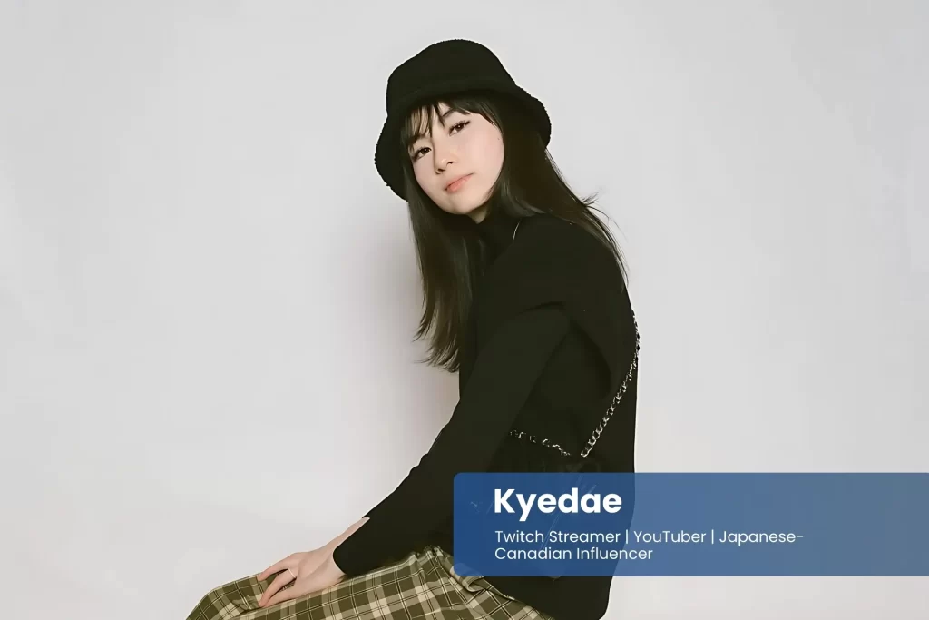 Kyedae wearing a hat and plaid skirt.