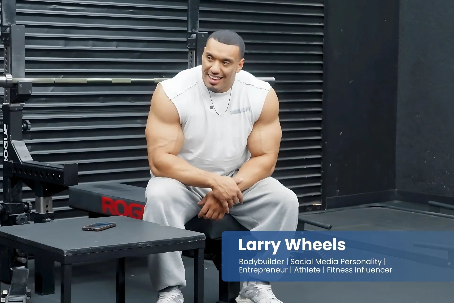 Larry Wheels sitting on a bench in a gym.