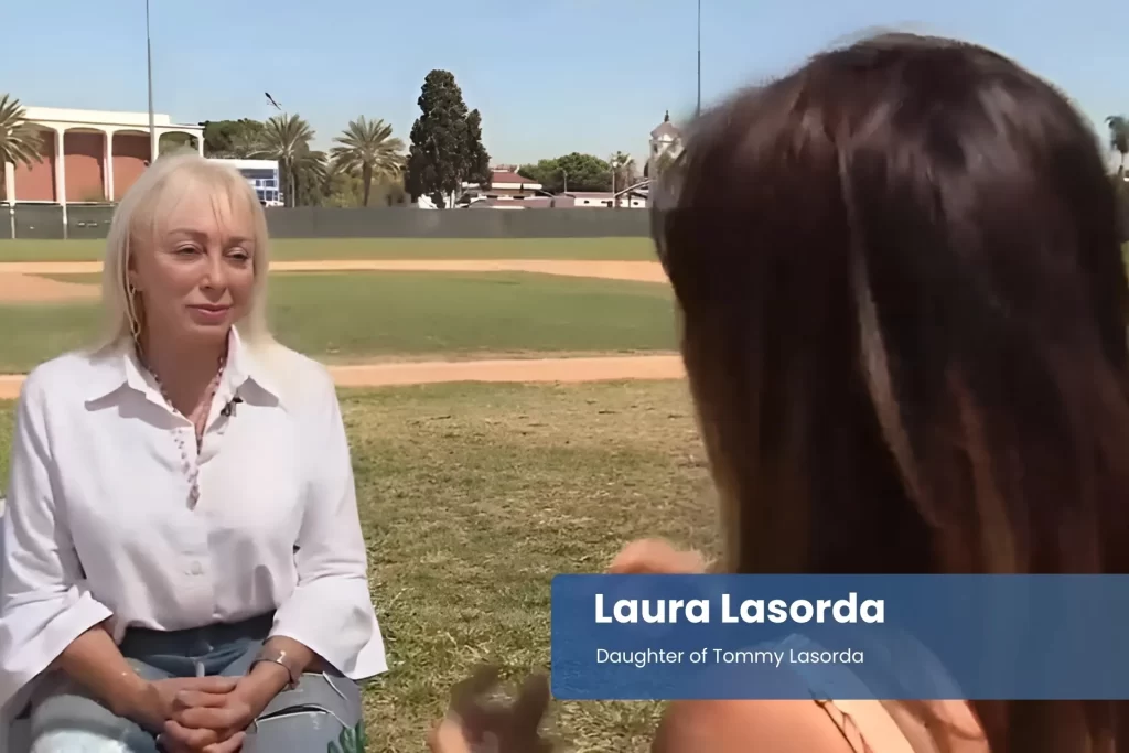 Laura Lasorda - Daughter of Tommy Lasorda, talking on a baseball field.
