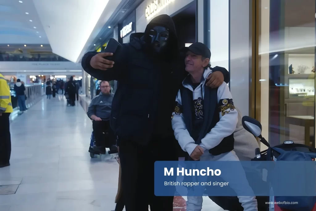 M Huncho posing for a picture in an airport.