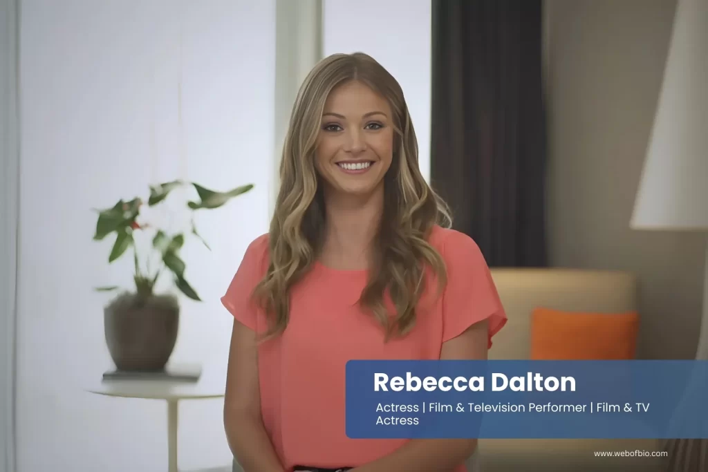 Rebecca Dalton in an orange top is smiling for the camera.