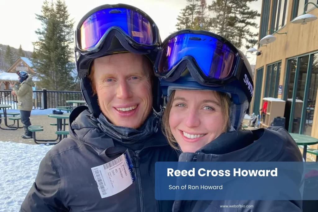 Reed Cross Howard and his wife in colorful ski outfits pose happily for a photo in a snowy environment.