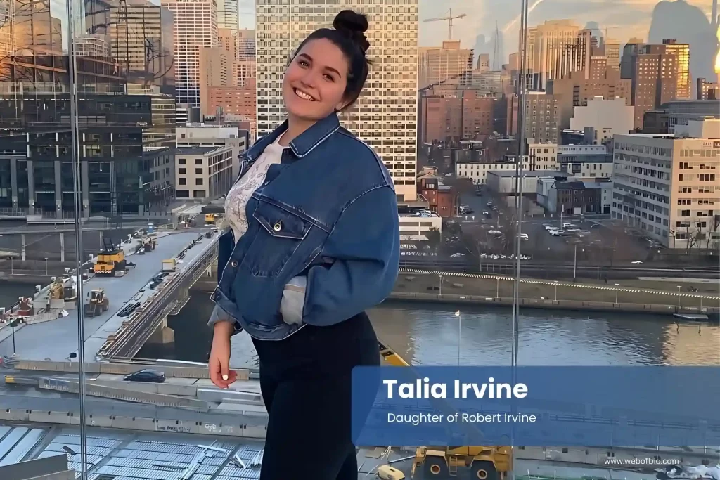 Talia Irvine - Daughter of Robert Irvinein in denim jacket standing in front of a city skyline.