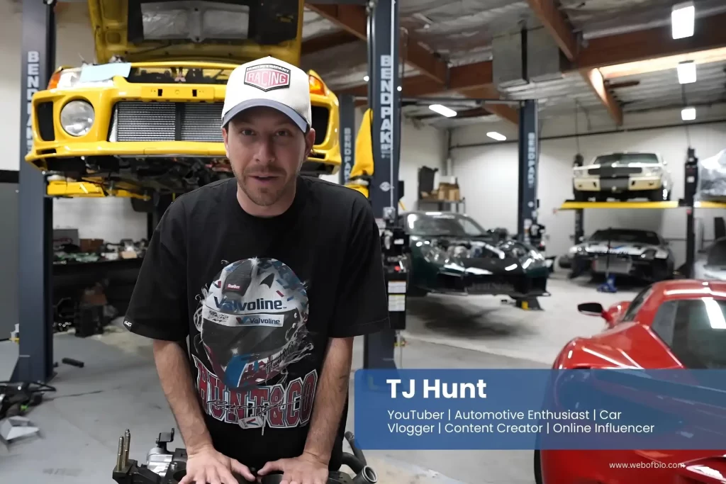 TJ Hunt standing in front of a car in a garage.