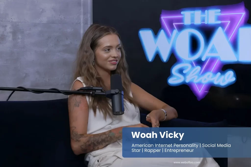 Woah Vicky is sitting on a couch with a microphone in front of them.
