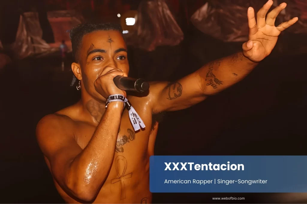 XXXTentacion performing with microphone enthusiastic audience.