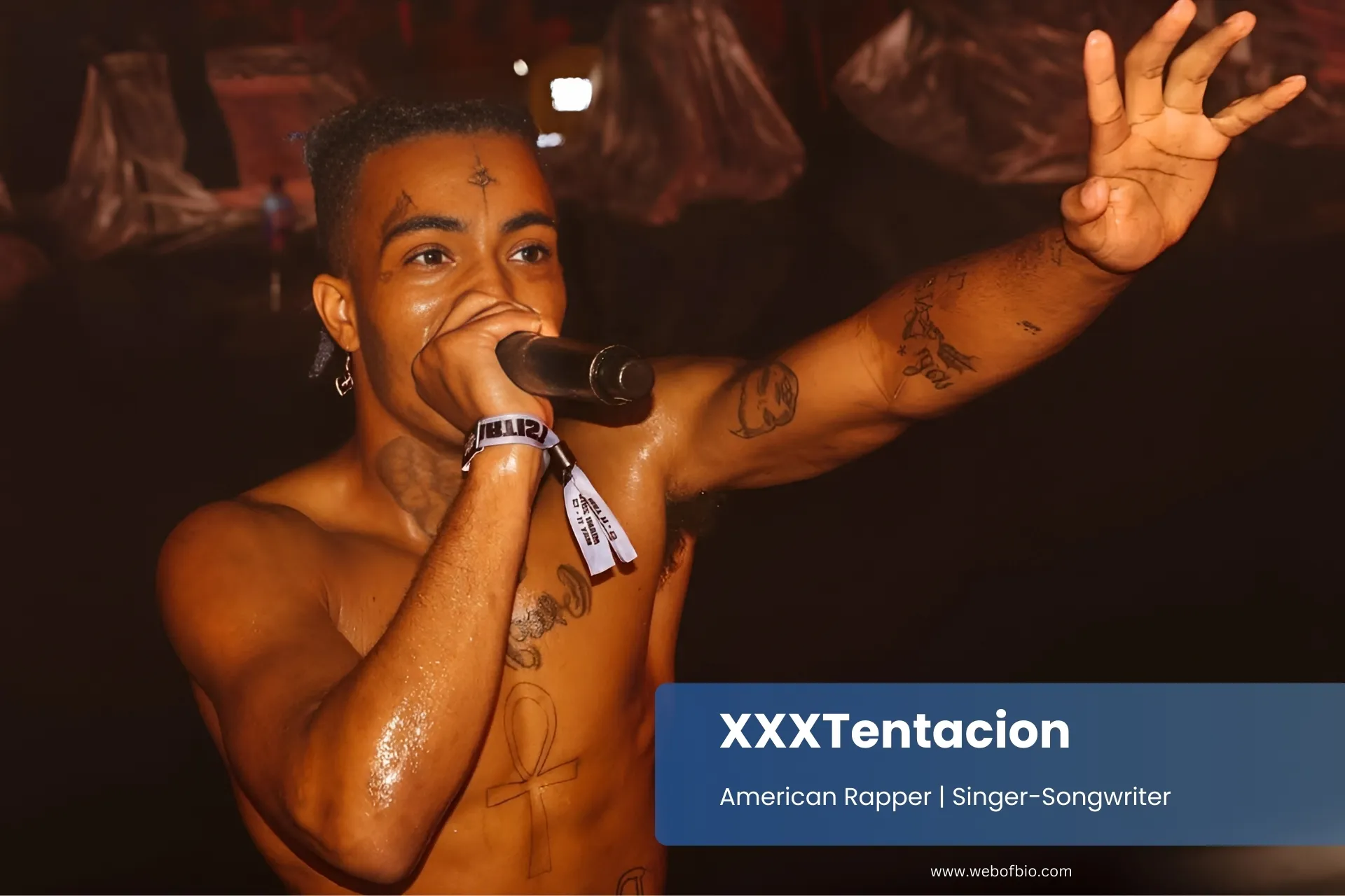 XXXTentacion performing with microphone enthusiastic audience.