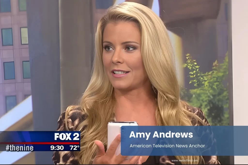 Amy Andrews holding cell phone by television.