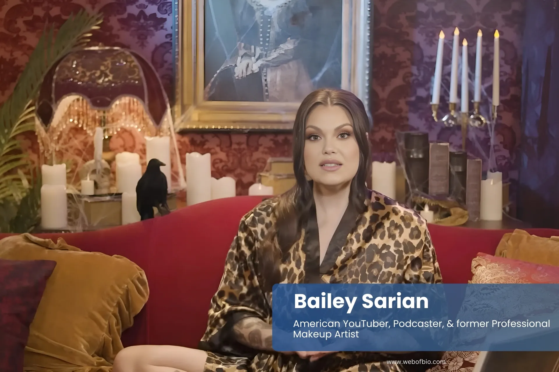 Bailey Sarian leopard print robe on red couch.