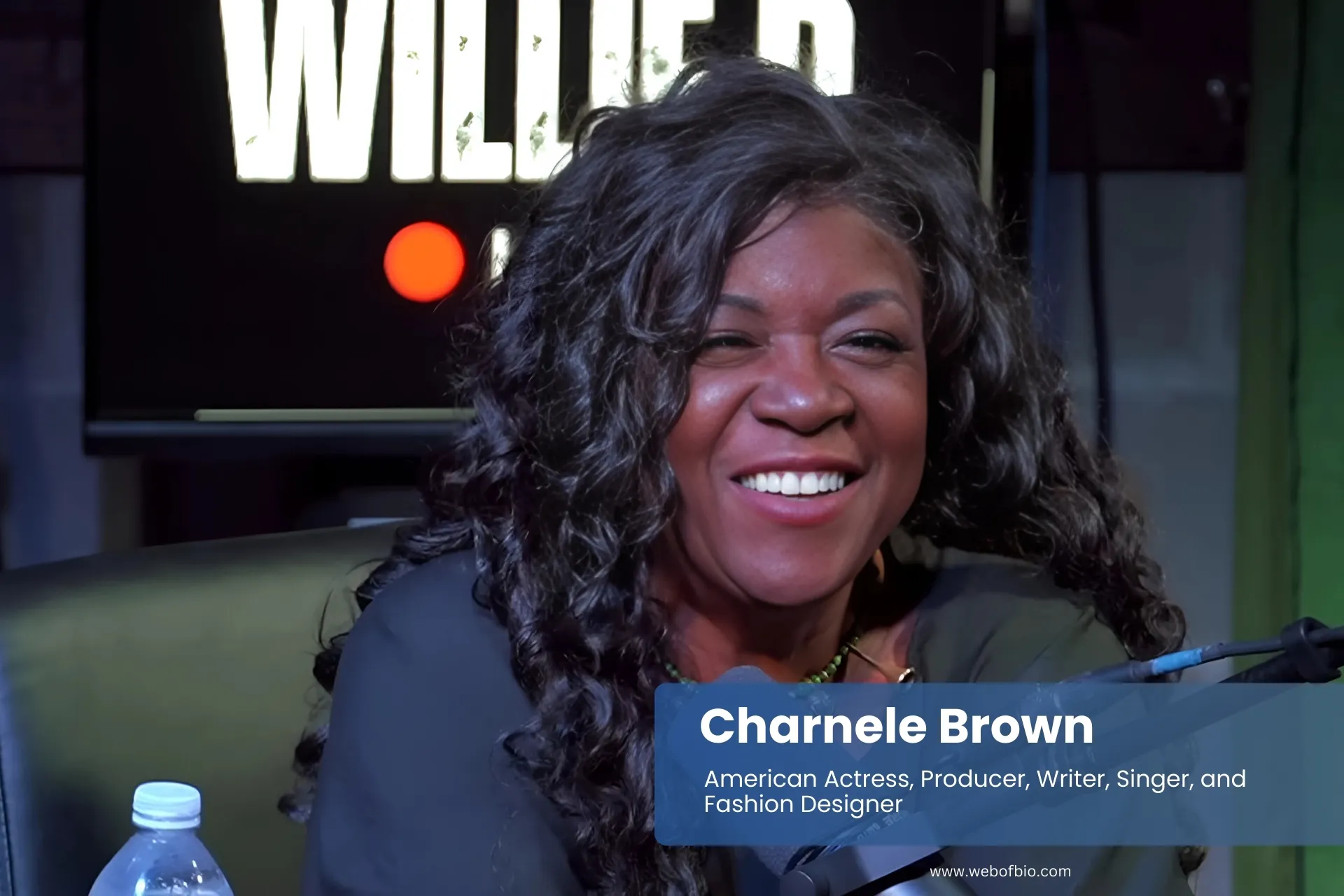 Charnele Brown sitting in chair with microphone, speaking.