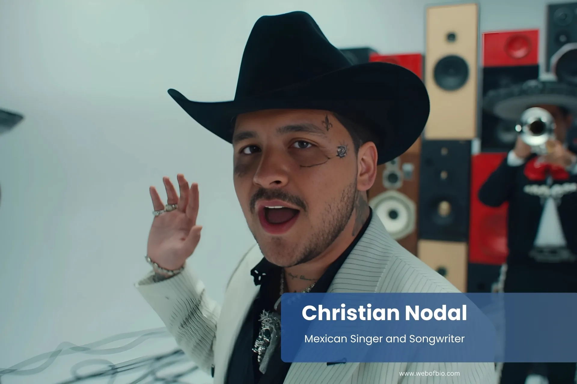 Christian Nodal suit and hat, performing song.